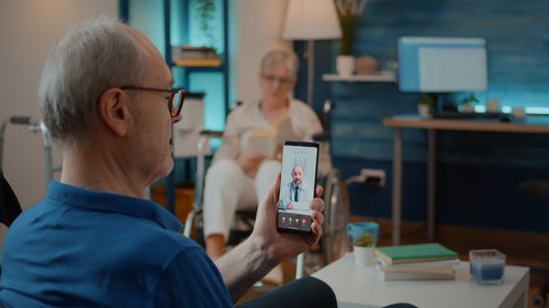 Älterer Erwachsener nutzt Videoanruf, um mit Arzt über Behandlung zu Hause zu sprechen.  